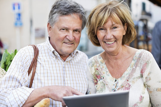Portrait of happy couple with digital tablet