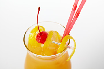 Orange cocktail drink with lemon and cherry isolated on white background
