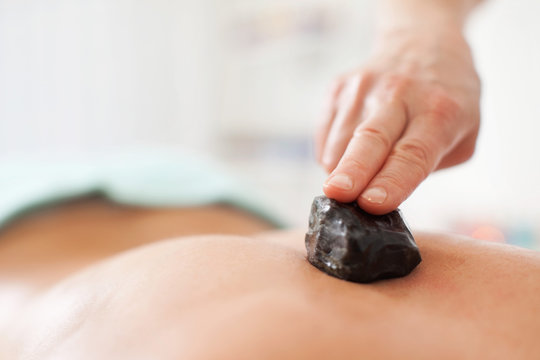 Close-up of a mid adult woman's back getting lastone therapy