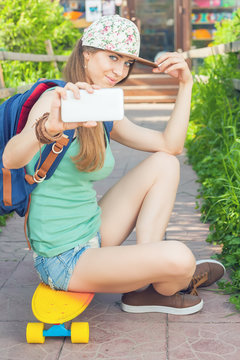 Awesome skateboarder girl making selfie on mobile phone