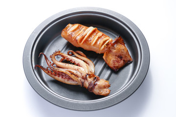 Grilled squid on frying pan over white background