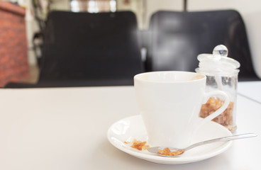 cup of coffee and sugar with magazine on white wood table