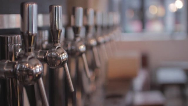Taps of Craft Beer In Pub, Rack Focus. A beer tap is a valve, specifically a tap, for controlling the release of beer.