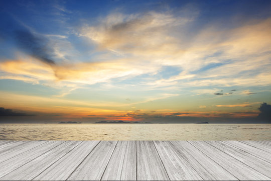 Perspective of wood terrace against beautiful seascape at sunset