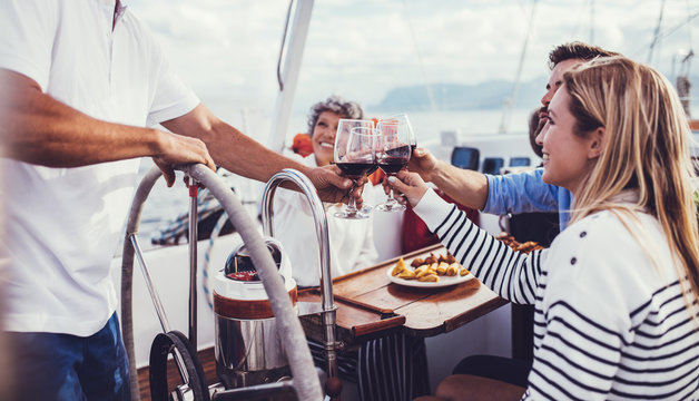 Friends toasting with red wine on yacht