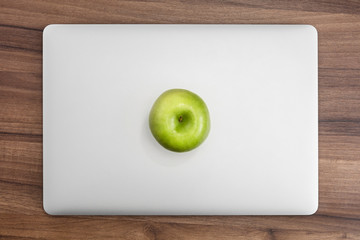 MacBook pro on wooden desk with apple - obrazy, fototapety, plakaty