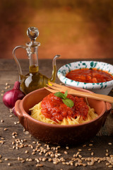 Bowl of pasta all 'egg and bowl with tomato sauce and oil cruet
