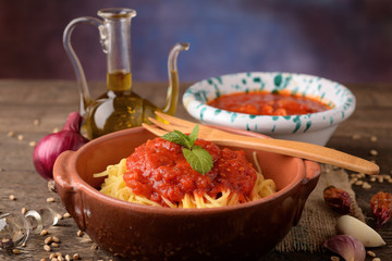 Bowl of pasta all 'egg and bowl with tomato sauce and oil cruet

