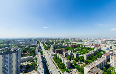 Fototapeta na wymiar Aerial city view with crossroads and roads, houses, buildings, parks and parking lots, bridges. Urban landscape. Copter shot. Panoramic image.