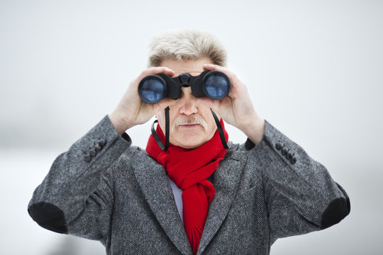 Mature  man holding binoculars