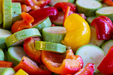 Sliced circles pickled vegetables for grilling. Courgettes, zucchini and sweet pepper with spices and oil. Selective soft focus.