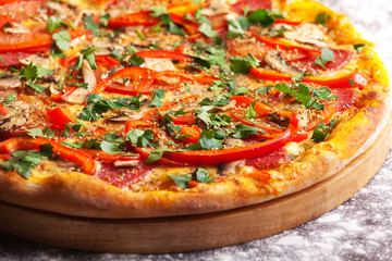 Pizza with salami, tomatoes, paprika and mushrooms isolated on white