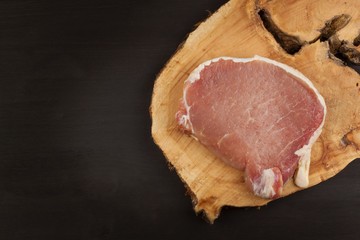 Raw meat pork steak on a cutting board. Preparing barbecue pork steak. Sales of pork on the grill. Advertising on butcher. Raw pork butcher.
