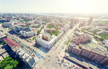 Aerial city view with crossroads and roads, houses, buildings, parks and parking lots, bridges. Urban landscape. Copter shot. Panoramic image.