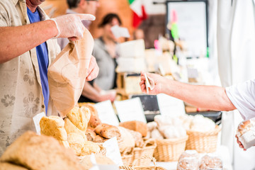 man sells bread at market stall