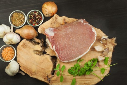Raw meat pork steak on a cutting board. Preparing barbecue pork steak. Sales of pork on the grill. Advertising on butcher. Raw pork butcher.
