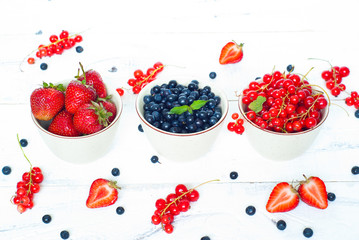 Three little bowls with different berries