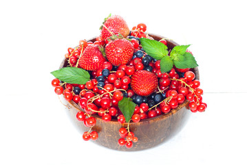 Different berries in wooden bowl