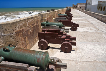 Morocco. Essaouira. The ramparts with brass cannons from the 18th and 19th centuries - a panoramic view over the cliff and the ocean. This site was added to Unesco's World Heritage list