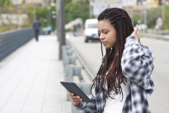 young woman with the tablet on the street