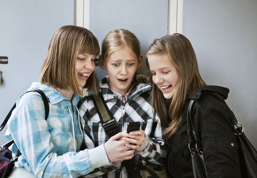 Three friends looking at telephone
