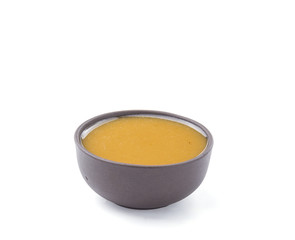 Vinaigrette sauce in brown bowl isolated on white background. Closeup.