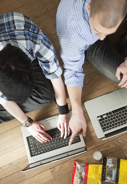 Two people helping each other by the computer