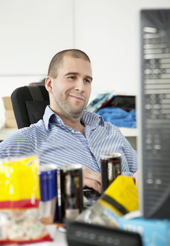 Man smiling behind computer