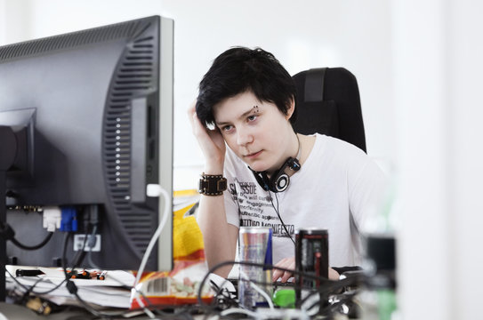 Young woman sitting by computer