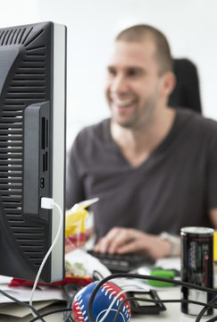 Smiling man sitting by computer