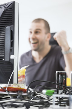 Man cheering behind the computer screen