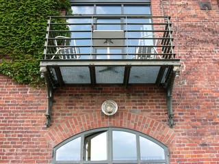 Moderner Balkon aus Eisen an der Backsteinfassade eines ehemaligen Speicher im Hafenviertel oder...