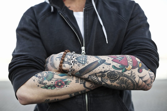 Close up of man's arms with tattoos
