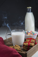 Hot milk in a glass with doughnut on wood