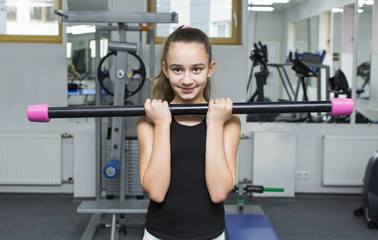 Fototapeta premium Girl is engaged in sports and gymnastics in the gym