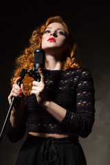 Portrait of curly-haired singer with red lips holding mic