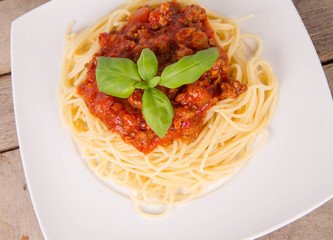 Spaghetti bolognese on a plate on a wooden background