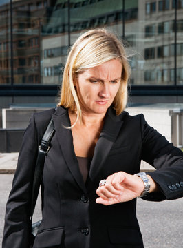 Businesswoman looks at her watch