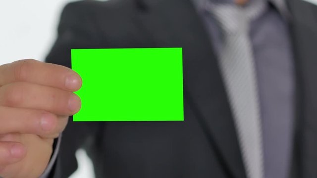 male hand giving showing a green business card to the camera pre keyed