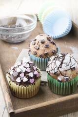 Photo of tasty cupcakes with chocolate over wooden table