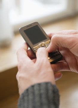 Man sending a text message on his cell phone