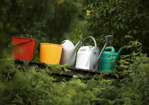 Buckets and watering cans in a row