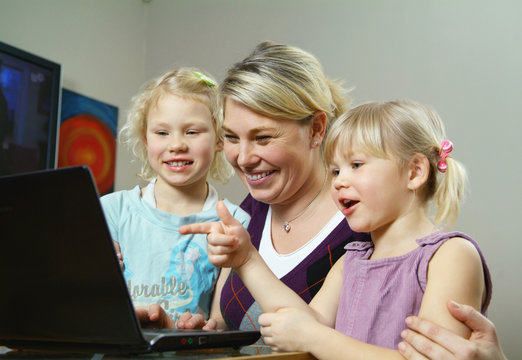 Mother and daughters in front of computer