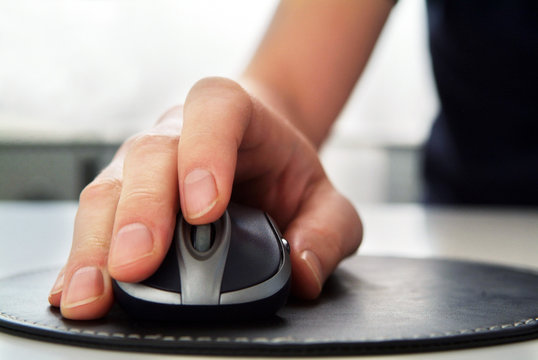 Hand clicking on computer mouse