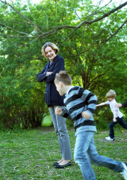 Boys running in circles around grandmother