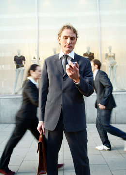 Businessman stopping and looking at his phone