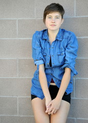 Female beauty expressions against a wall outside.