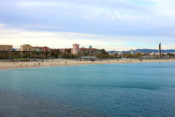 Fototapeta na wymiar Barcelona landscape, view from Port Olimpic on Mediterranean sea, Playa de la Nova Icaria and skyscrapers.