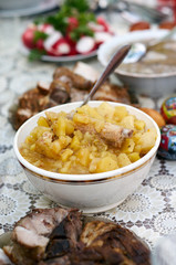 Vertical selective focus shot of an assortment of meals.Mashed Potato with pork ribs in bowl with serving spoon.Meal accompanied slice of boiled salted pork,sausage,boiled eggs,radish,fresh vegetables