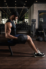 Fototapeta na wymiar Man In The Gym Exercising Biceps With Dumbbells